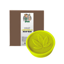 Load image into Gallery viewer, The image shows a round, yellow-green soap bar with a hemp leaf design on top, labeled "Lady Green Hemp Soap Bar" from the brand Green Apron. Behind the soap is a brown box with a label featuring an illustration of a woman holding a plant, and product information beneath—perfect for those who love the zest of limoncello.