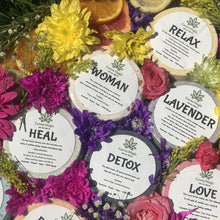 Load image into Gallery viewer, A vibrant display of Canna Magic Handmade 100mg CBD Bath Bombs—Relax, Woman, Lavender, Heal, Detox, and Love—by Canna Magic, surrounded by fresh flowers and citrus slices to highlight the beauty of CBD skincare.
